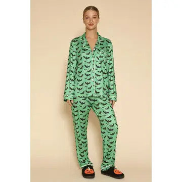 Person wearing green bat pajamas  on a beige background